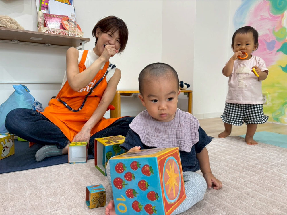 先生と赤ちゃんが教材で遊ぶ温かい場面