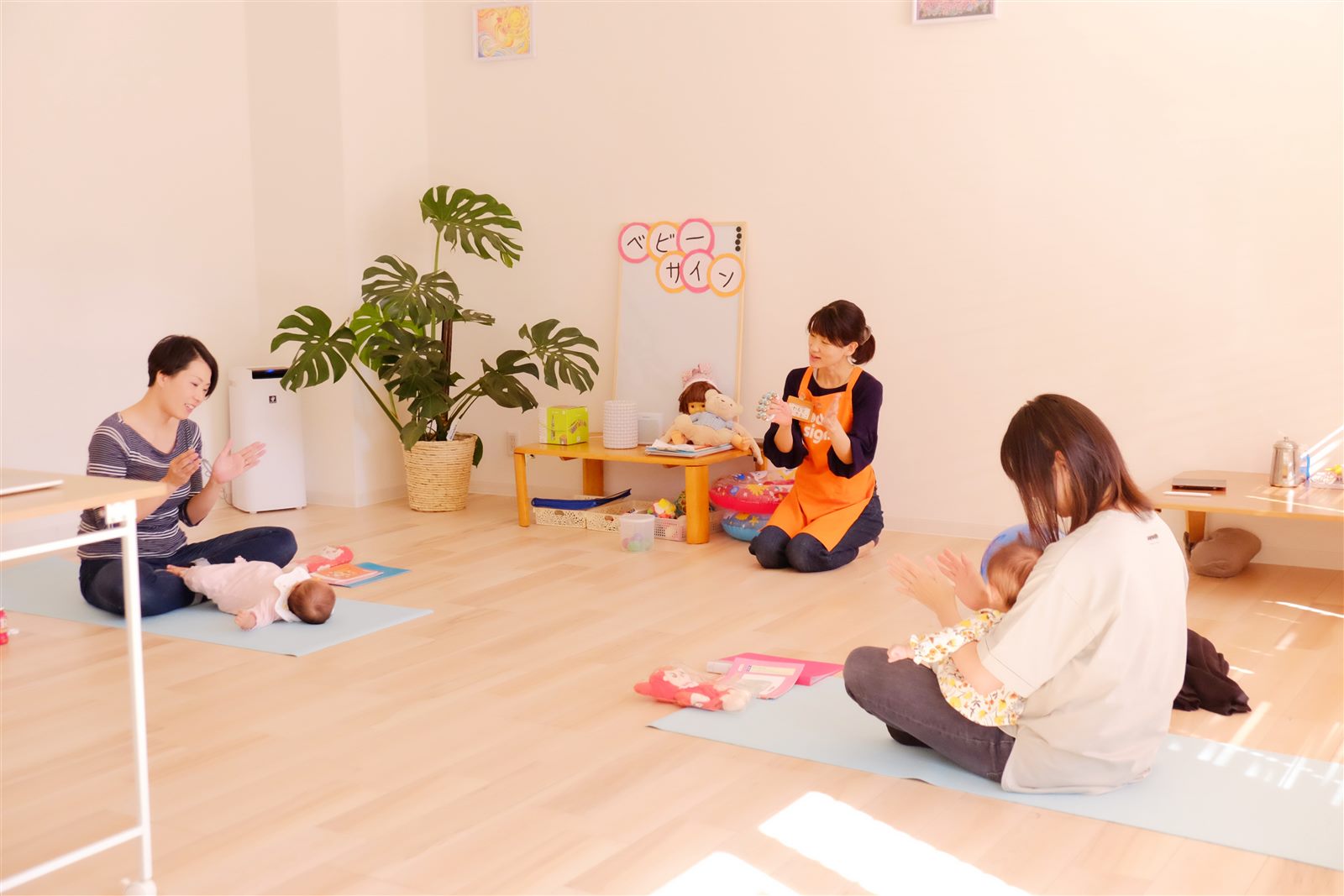 Studio Liko ベビーサインクラス ― 岩本先生がサインを実演し、2組のママと赤ちゃんが一緒に学ぶ場面
